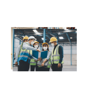 a group of people in safety gear standing in a warehouse