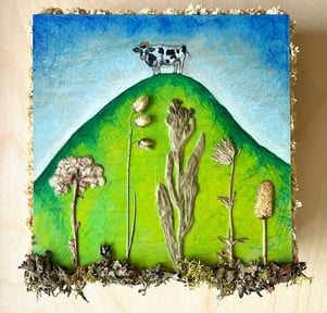 a painting of a cow on a hill with pressed flowers