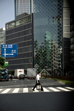 a man walking across a crosswalk in a city