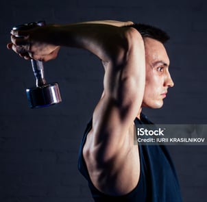 man doing dumbbell extension exercise