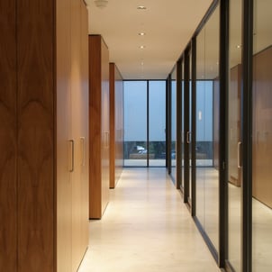 pasillo con mamparas de cristal y paredes revestidas en madera