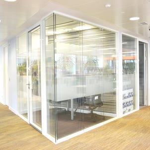mamparas de cristal con perfiles color blanco y moqueta beige marca Shaw