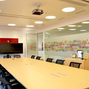 Sala de reuniones con mampara de cristal y paneles acusticos en las paredes