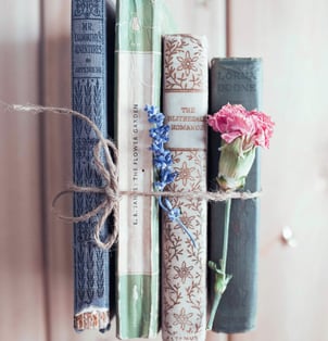 stack of ancient books with flowers - symbolizing learning & growth