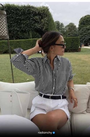 a woman in a striped shirt and white shorts