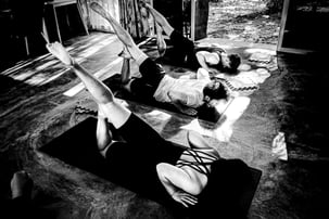 Practioners practice Locust Pose in a yoga class