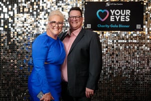 2 guests smiling in front of the SweetAz Co. silver shimmer wall hired for the Layton Vision Foundation Charity Gala Herston