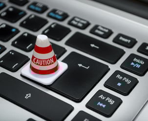 Mini caution cone on a keyboard symbolizing fast and careful product development at Braske Agency