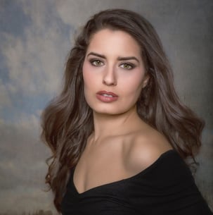 a woman in a black dress posing for a portrait