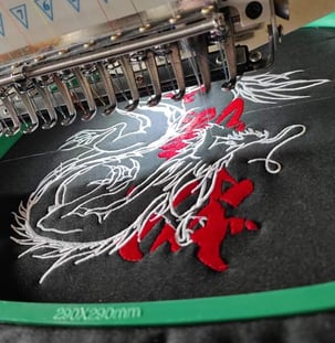 a machine embroiderying a picture of a embroidery machine