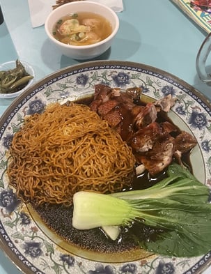 Cha sieuw or char siu mee/noodles in a dark sauce with bokchoy and wonton soup on the side 
