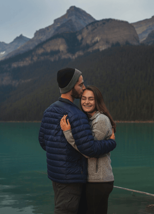 a man and woman standing in front of Lake Louise 