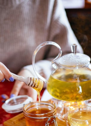 a person pouring tea into a teapot