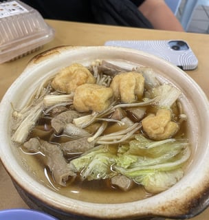 Bak kut teh, a pork bone broth with ribs tofu cabbage enoki mushrooms and pig intestines