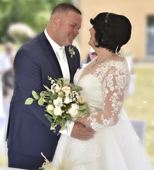 a bride and groom standing in front of a table