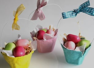 a group of three baskets with eggs and a bow tie