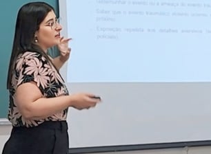 Foto da psicóloga apresentando seu artigo científico