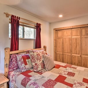 Guest bedroom with pinewood closet and cozy mountain quilt décor at Moose Creek Lodge.