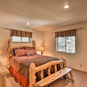 Rustic-style bedroom with handcrafted log bed, cozy bedding, and mountain views.