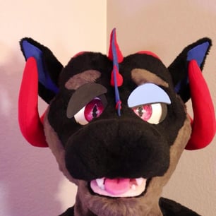 A dragon head made by Teto Creations featuring large curly horns, expressive moving eyelids and silicone teeth