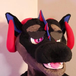 A dragon head made by Teto Creations featuring large curly horns, expressive moving eyelids and silicone teeth