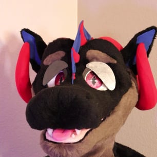 A dragon head made by Teto Creations featuring large curly horns, expressive moving eyelids and silicone teeth