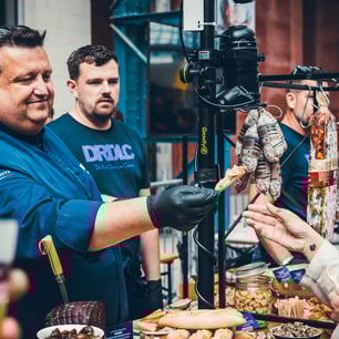 Un cuisinier tendant de la nourriture à quelqu'un dans la foule