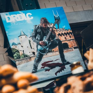 Une affiche accrochée au mur montrant un guitariste jouant dans une rue