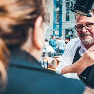 homme à lunettes faisant un signe de la main