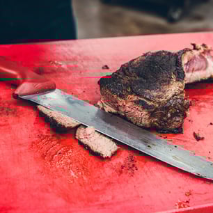 Un couteau de cuisine posé sur une planche à découper près d'une côte de boeuf