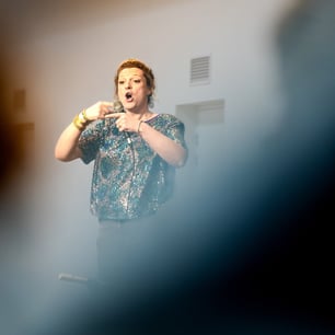 Une intervenante sur scène et s'exprimant en ouvrant la bouche