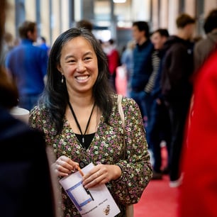 Une jeune femme souriante tenant un papier dans les mains