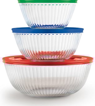 a stack of three pyrex bowls with plastic lids