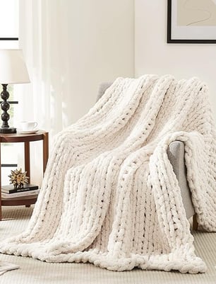 a white knitted blanket on a couch