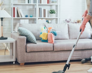 a woman in a striped shirt is cleaning a couch