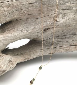 Sautoir de style chapelet, posé sur un tron de bois flotté
