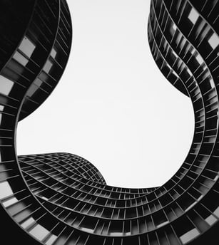 Vue d'en dessous d'un bâtiment aux murs courbés, noir et blanc