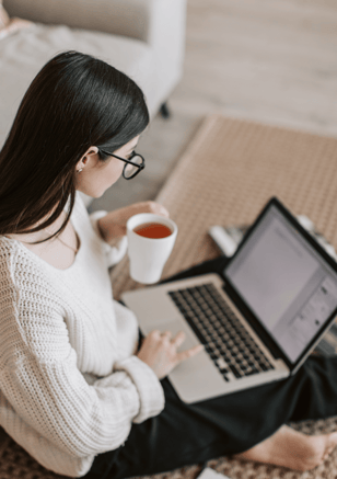 Woman learning about fertility options online with laptop and coffee.
