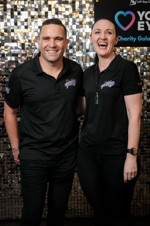 Carly and Kahn from Sweetaz Co. in front of the silver shimmer wall at the Layton Vision Foundation charity event in Brisbane
