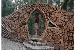 Femma debout faisant l'expérience dêtre dans 1 trou en losange au milieu d'1 tas de bois