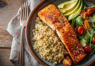 prato com salmão grelhado, quinoa, salada fresca com abacate, tomates-cereja e um vinagrete leve
