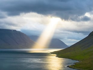 sun beam coming through clouds onto ocean