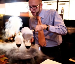 a man in a tie and shirt making molecular cocktails