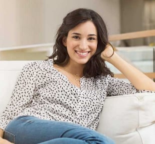 a woman sitting on a couch with her legs crossed