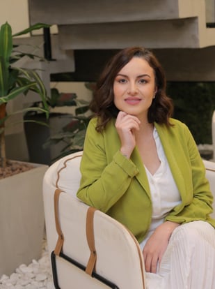 Contemplative mentor in green blazer, seated with grace