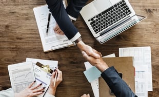 a group of people shaking hands over papers