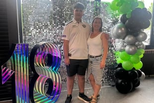 Jayden and mum in front of a silver shimmer backdrop with 18 marquee number at his birthday at the Distillery Beenleigh.