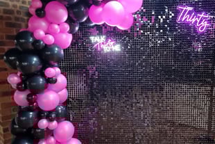 Black shimmer wall with pink neon and black balloon garland, pink Thirty neon for Kristen's 30th birthday.