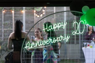 SweetAz Co. circle backdrop with a glowing green ‘Happy 20th Anniversary’ neon sign at a vow renewal event in Redland Bay, wi