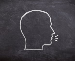 a chalkboard with the drawing of a head in profile talking